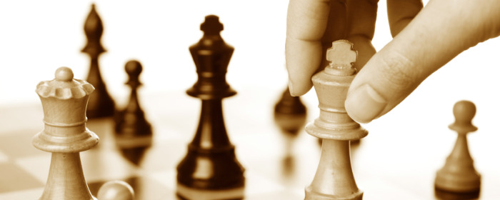 A hand moving the king in a chess game.